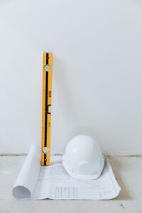wasserwage nebend helm stehend auf bauplan