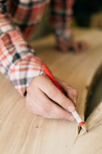 zimmermannsbleistift in hand gehalten genutzt zum anzeichnen auf holz